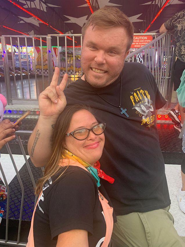 Andrew and Jasmine together at a fair, smiling at the camera