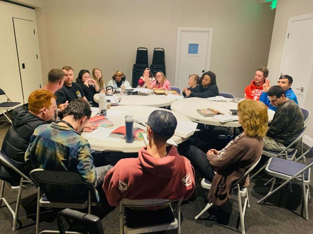 Friends gathered around tables to learn God's Word