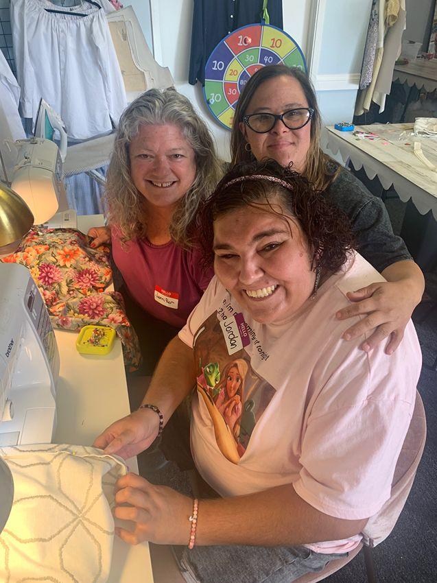 Friends sewing together, sharing a joyful moment of community