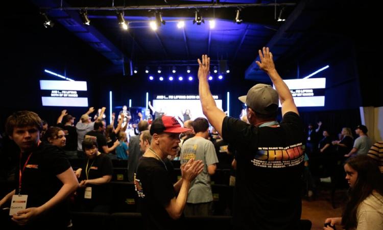 Friends lifting hands in worship together