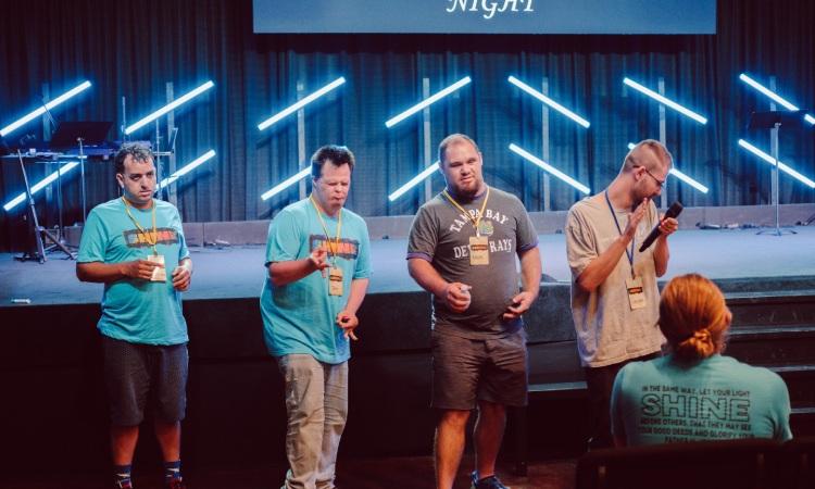 Friends participating on stage during the service